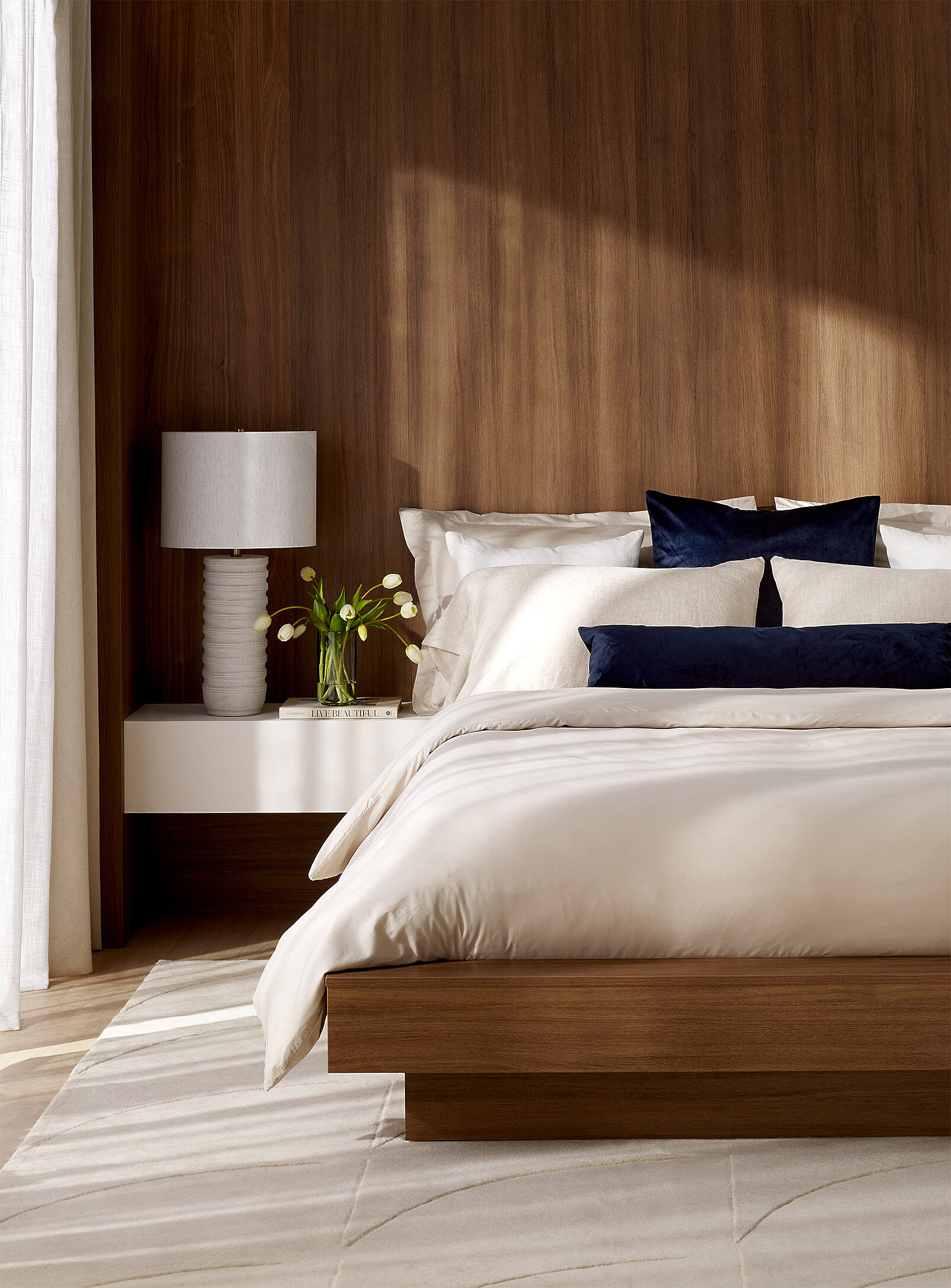 Hotel room — queen bed in foreground, windows looking out onto city