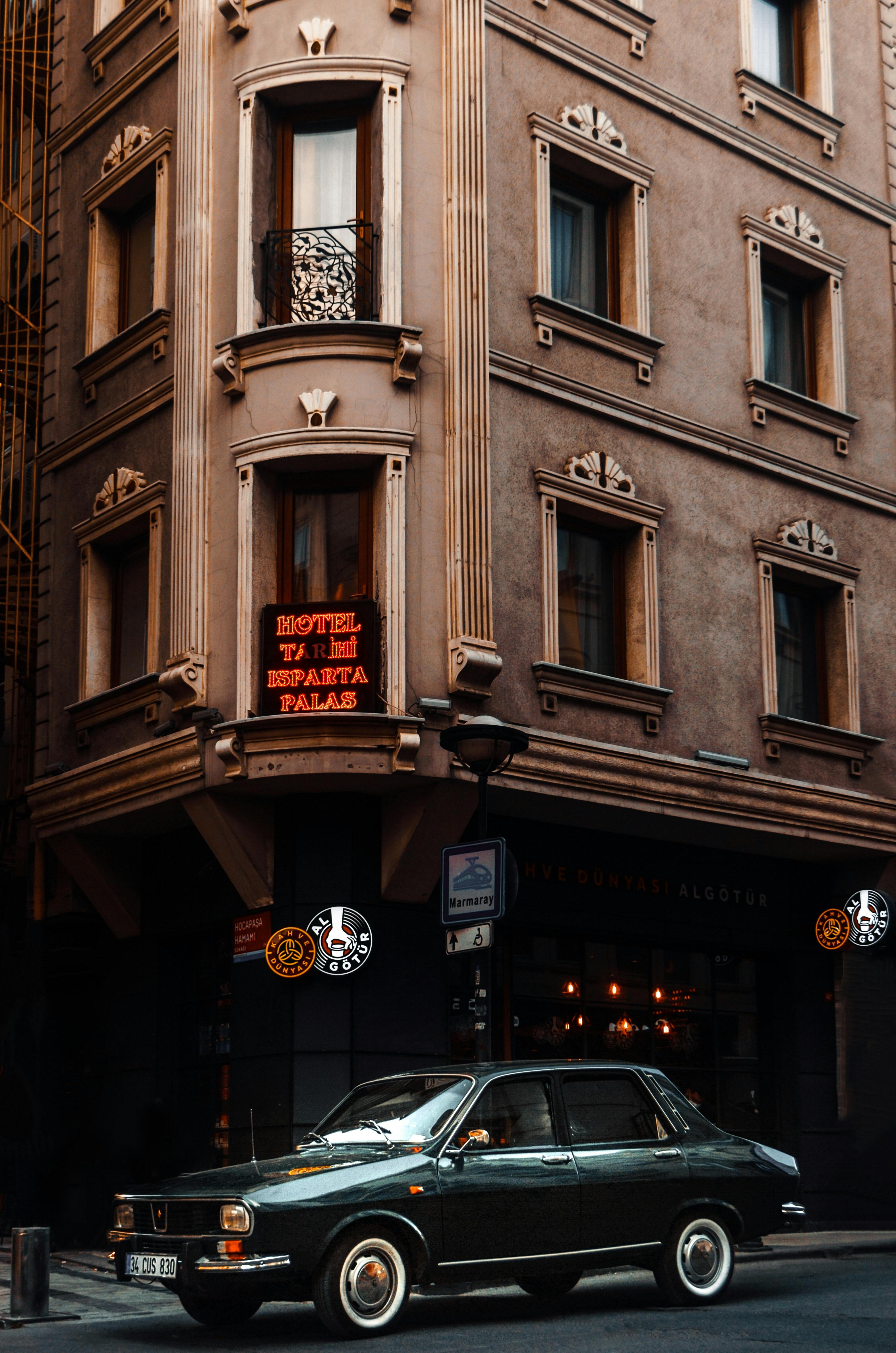 The corner — neon sign, vintage car, evening falls